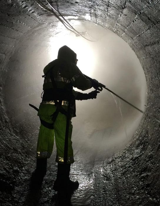 Rescue worker using water hose inside tunnel